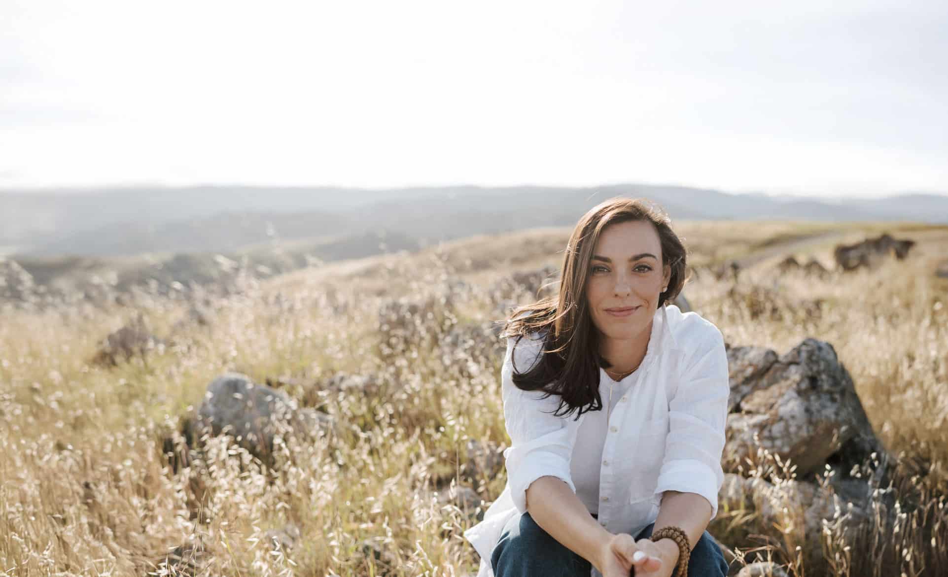 Clare Johnson, LMFT, sitting in a sunny field