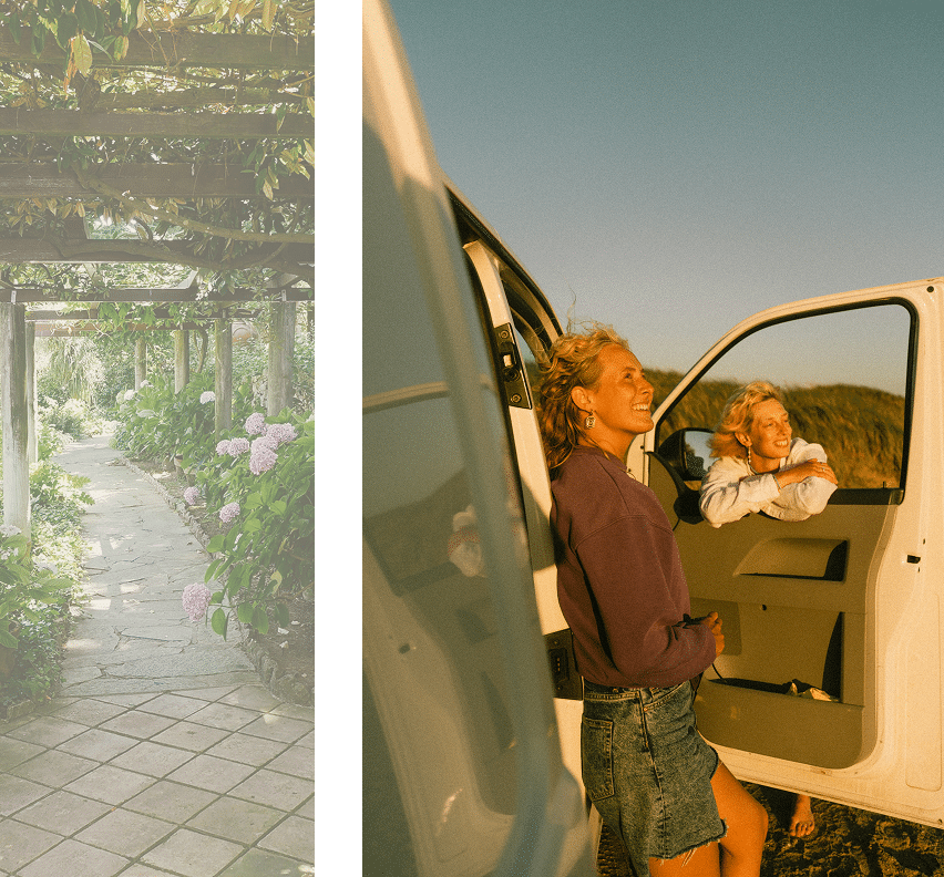 Two women laughing beside an open car door, next to a garden path